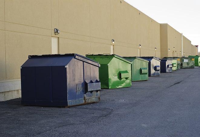 a row of construction dumpsters parked on a jobsite in Hartsfield